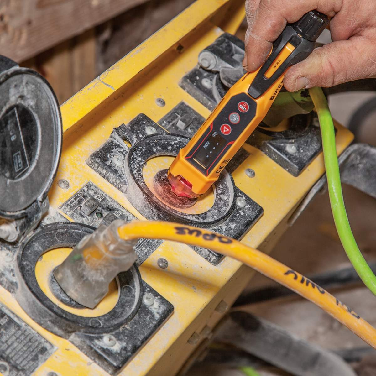 Professional application shot of the NCVT6 being used to test an industrial-grade outdoor power distribution box. The red visual indicator is active, demonstrating the tool's reliability in identifying live AC voltage in heavy-duty commercial settings.