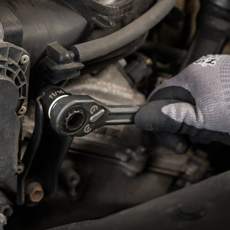 Mechanic using the Klein low-profile pass-through ratchet with an 11/16-inch socket to turn a fastener inside an engine compartment.