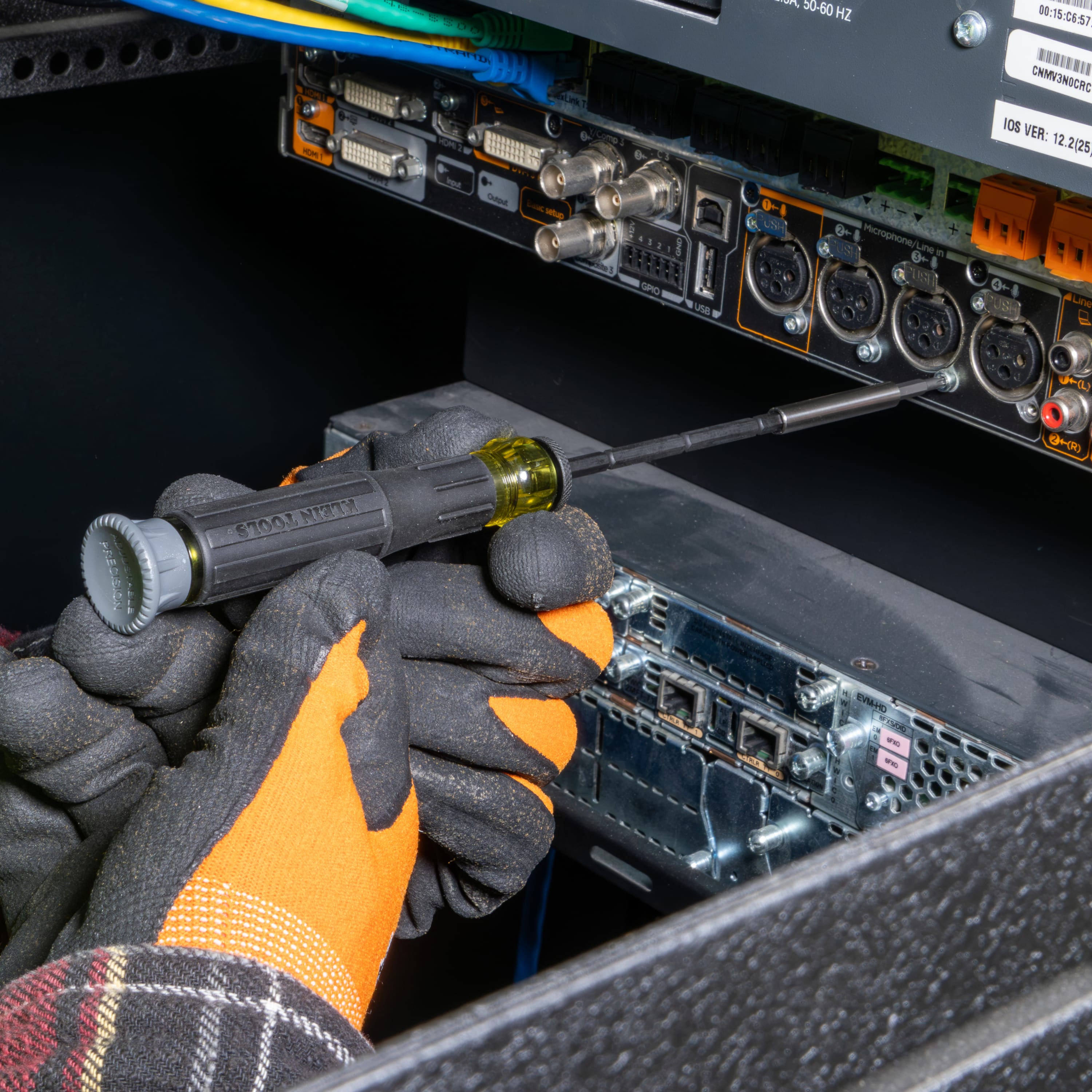 Technician using the adjustable precision screwdriver to service small screws on a rack-mounted server network interface.