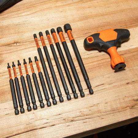 The Klein Tools Ratcheting T-Handle and a selection of the long and standard interchangeable bits laid out on a wooden workbench.