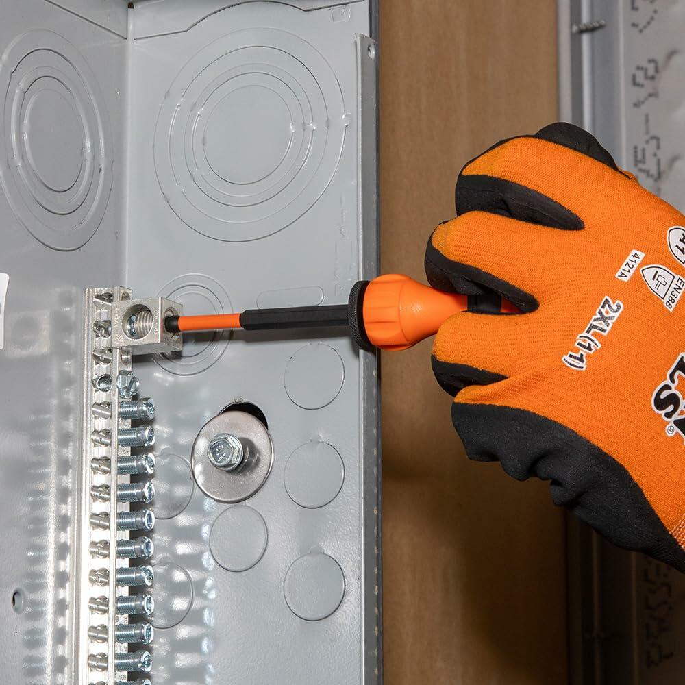 A worker uses the Klein Tools T-Handle with a long bit to tighten a screw on a grounding bar inside an electrical junction box.