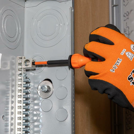 A worker uses the Klein Tools T-Handle with a long bit to tighten a screw on a grounding bar inside an electrical junction box.