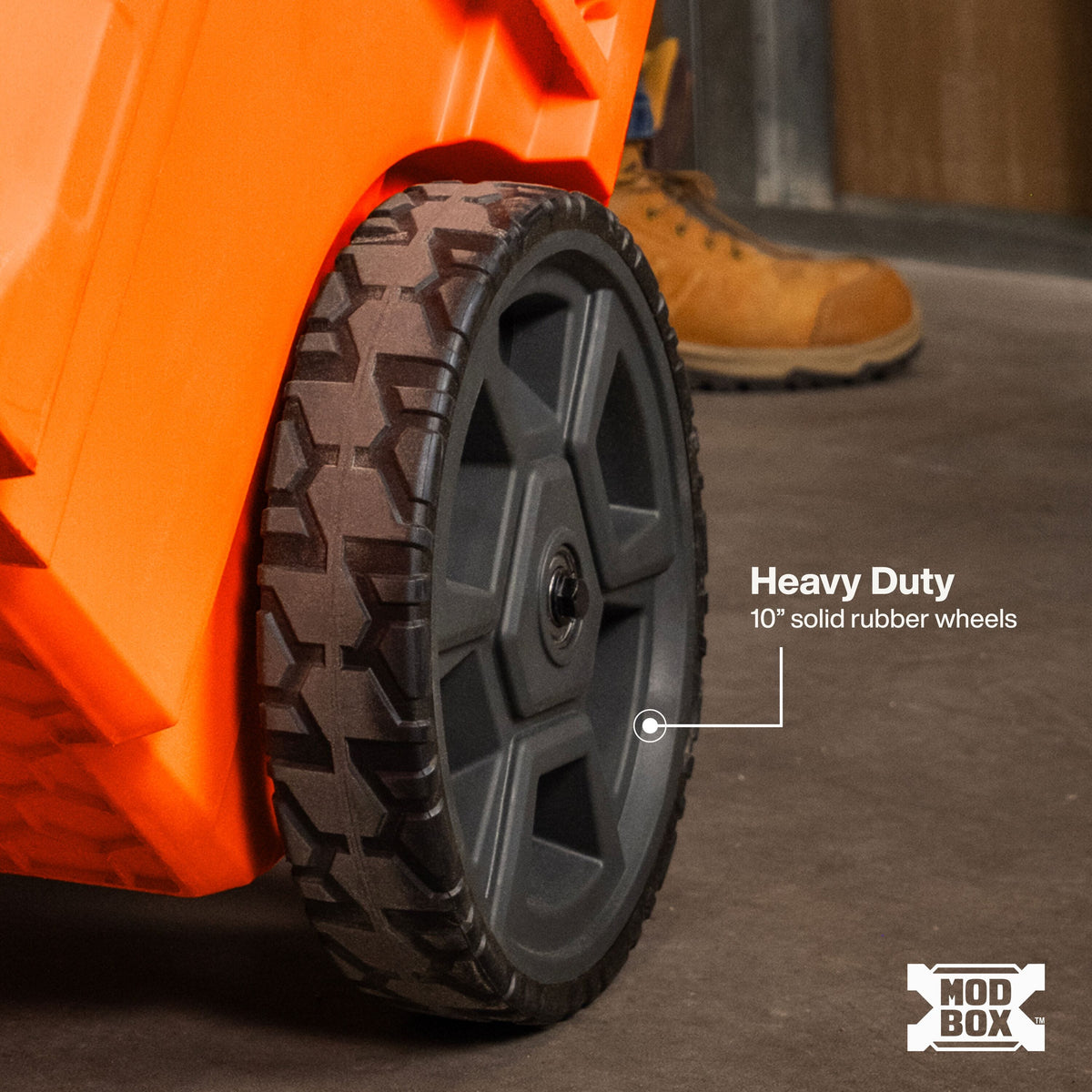 Heavy-duty 10-inch solid rubber MODbox wheels provide reliable ground clearance and smooth rolling over rough construction terrain.