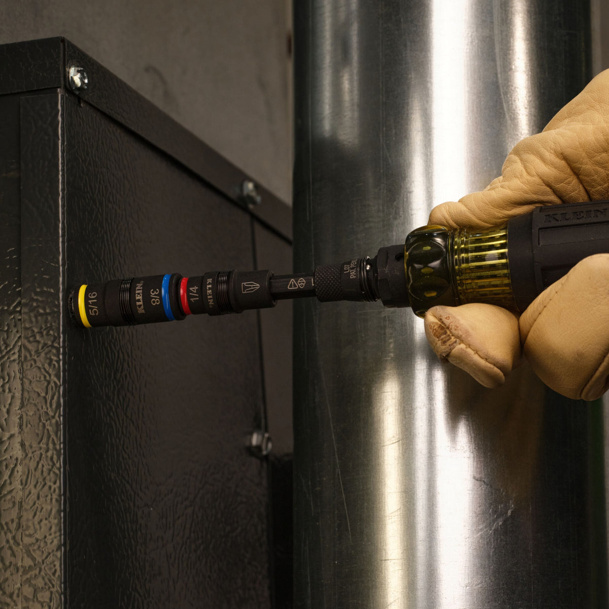 Contractor using the Klein Tools 32517HD screwdriver with 5/16-inch flip socket to secure an HVAC metal equipment cabinet panel.
