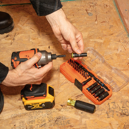 Contractor attaching a 5/16-inch impact socket onto a 1/4-inch quick-connect power adapter next to an open Klein 32502HD storage case.