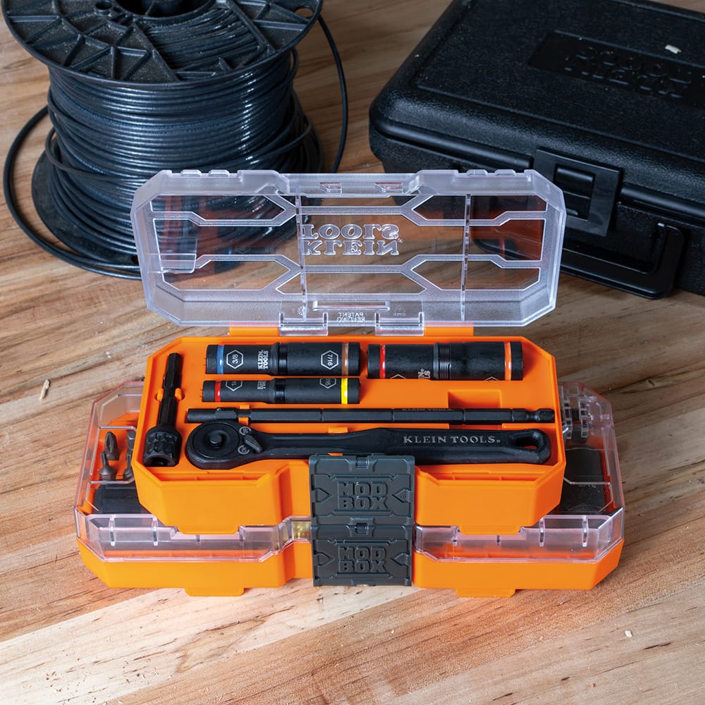 Klein Tools MODbox compact organizer case stacked on top of a larger storage case, demonstrating modular jobsite stacking compatibility.