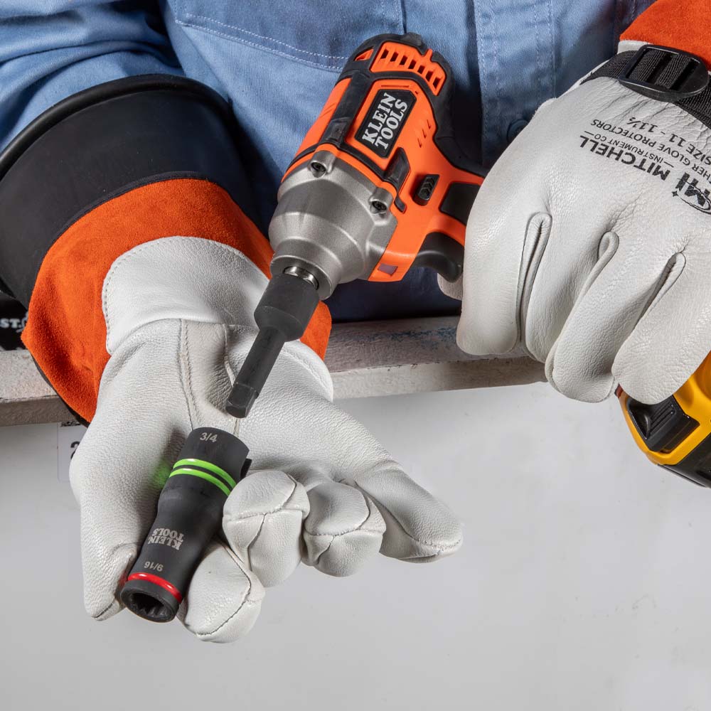 Lineman in high-voltage leather protective gloves reconfiguring the reversible 66044 flip socket on an impact driver shaft.