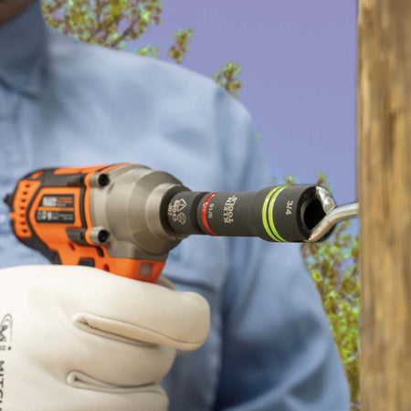 Lineman aligning the side slot of a 66044 impact socket over a curved eyebolt on a wooden power pole to demonstrate thread clearance.