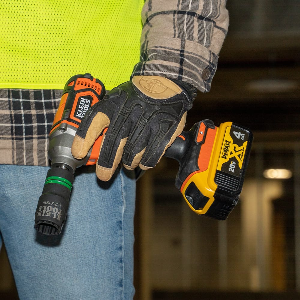 Technician carrying a 1/2-inch impact wrench equipped with a Klein 1-1/8 by 15/16-inch slotted coaxial socket for overhead utility work.