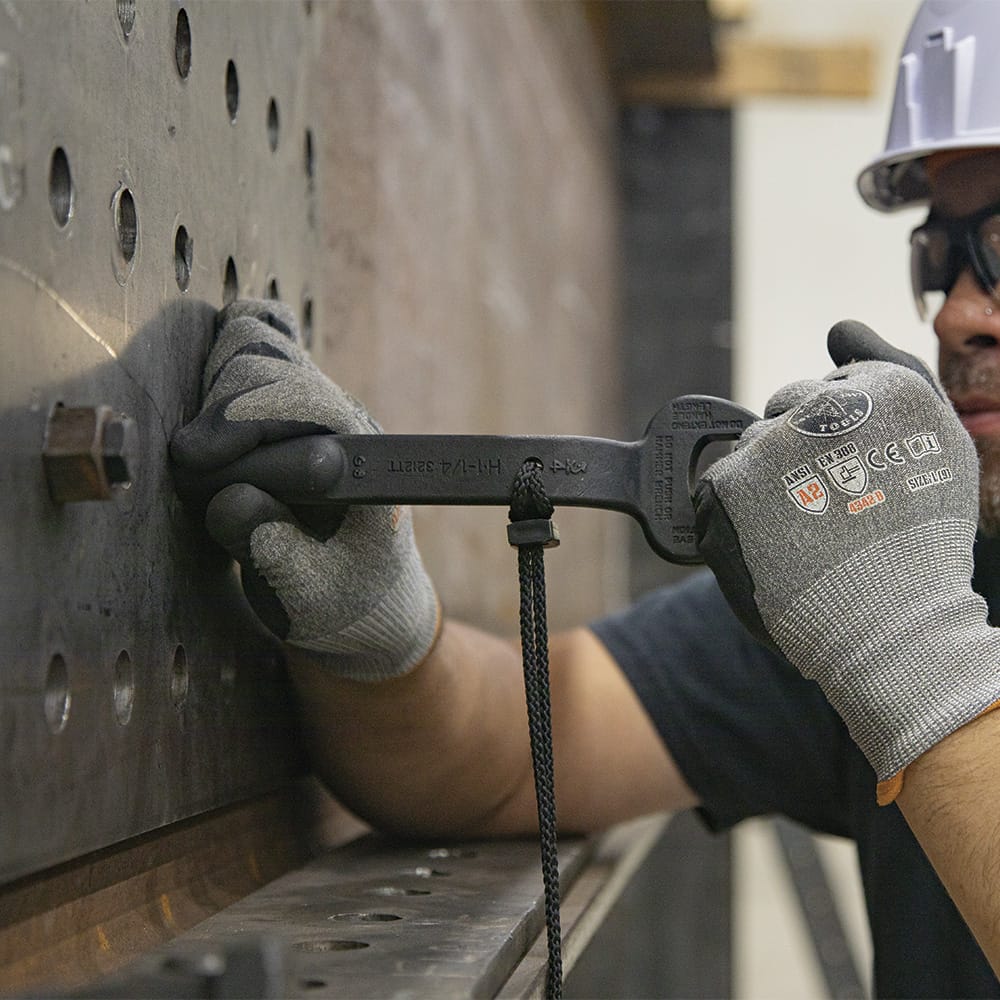 Ironworker leverage-aligning heavy steel connection plate bolt holes by inserting the tapered handle of a tethered Klein 3212TT spud wrench.