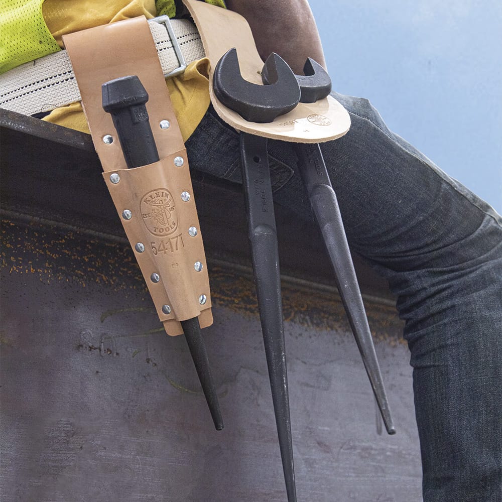 Leather tool frog setup carrying a Klein bull pin alongside two spud wrenches on an ironworker harness belt for structural connecting work.