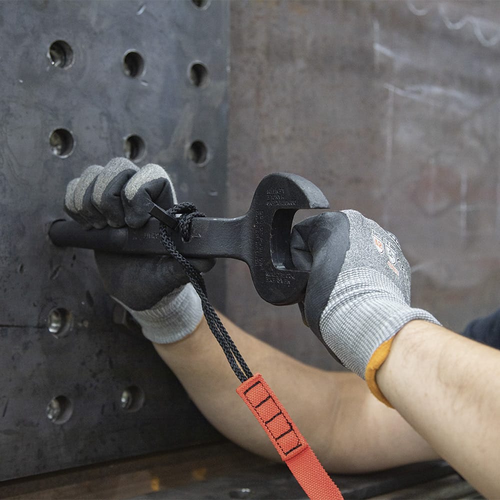 Ironworker inserting the 3214TT tapered handle into a multi-hole steel connection plate to align overlapping bolt holes on a jobsite.