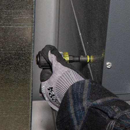 Technician using the Klein Tools 32561HDRT ratcheting stubby driver to tighten a hex head screw inside a tight HVAC metal equipment cabinet.