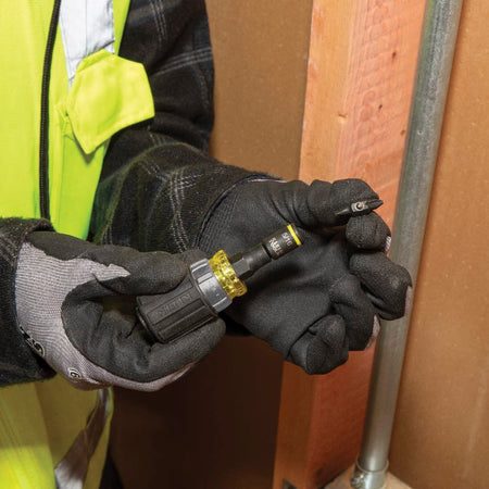 Electrician swapping a double-ended Phillips screwdriver bit into the 5/16-inch nut driver socket on the Klein 32561HDRT stubby handle.