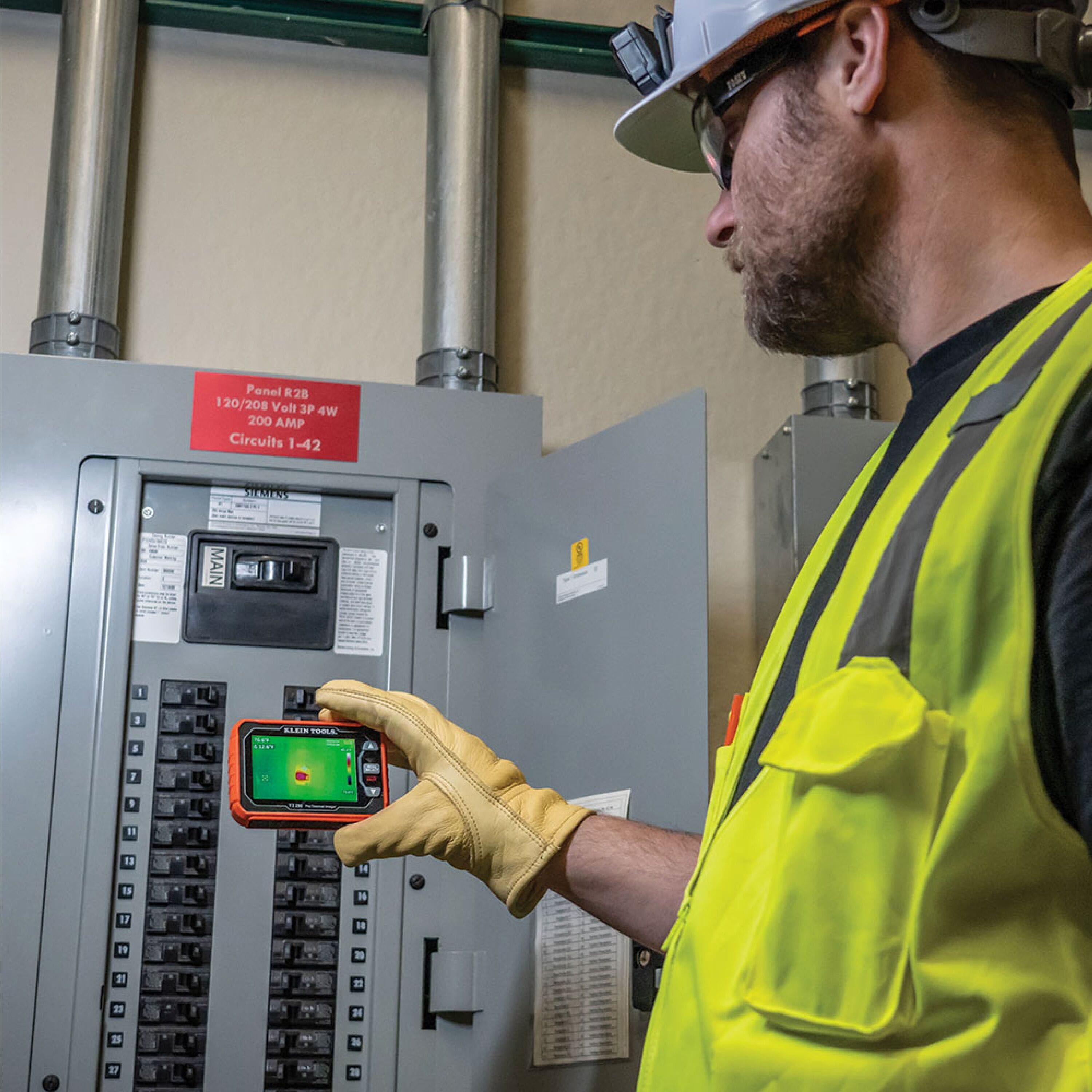 Action shot of a professional wearing leather work gloves using the TI290 Pro Thermal Imaging Camera to inspect a residential HVAC vent. The large 3.5-inch screen displays a high-resolution 76,800-pixel thermal map showing a differential temperature of 25 degrees Fahrenheit, helping to identify air flow issues or energy loss.