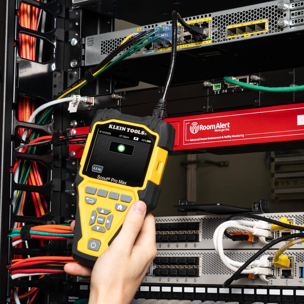 Action shot of a professional technician using the VDV501770 Scout Pro Max to identify a network port in a commercial server room. The high-resolution screen provides a clear wire map of the connection, demonstrating the tool's effectiveness for large-scale data center cable management and troubleshooting.