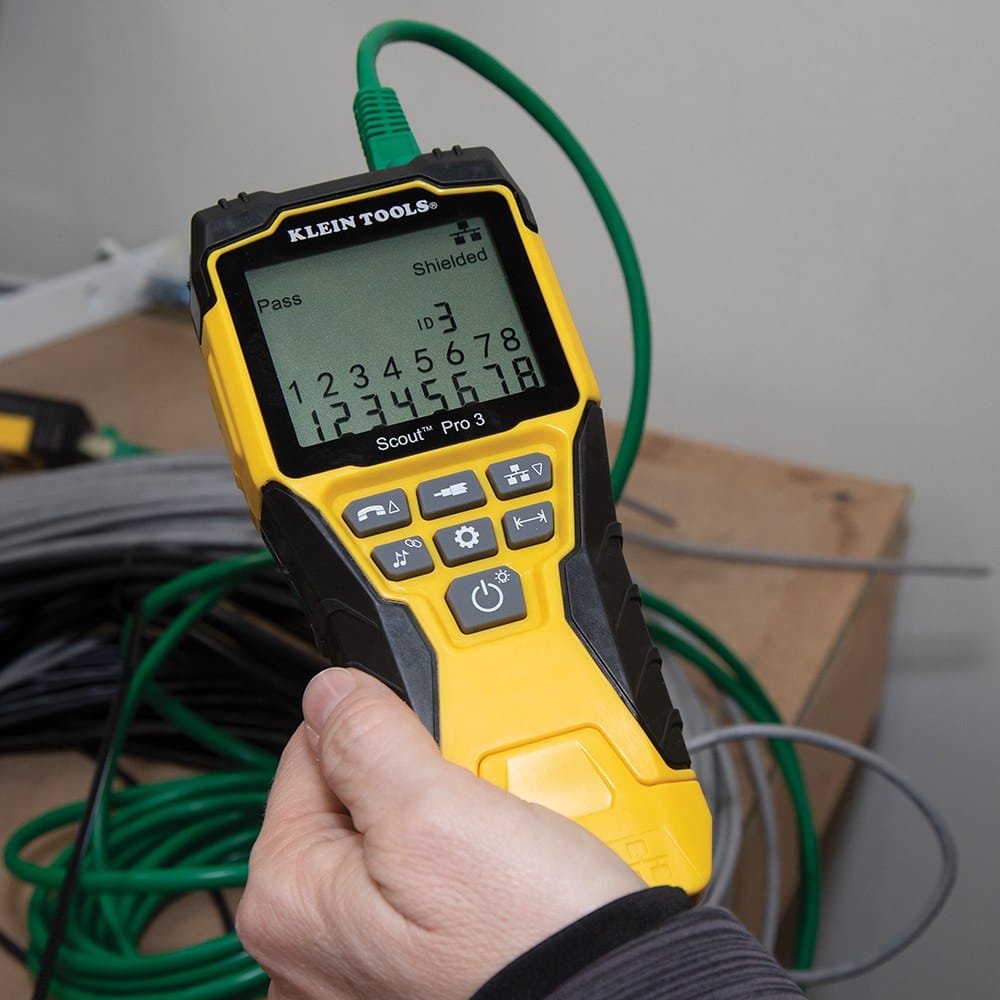 An action shot showing a person holding the Scout Pro 3 while connected to a green Ethernet cable, with the screen displaying a pass result, shield confirmation, and wire map.