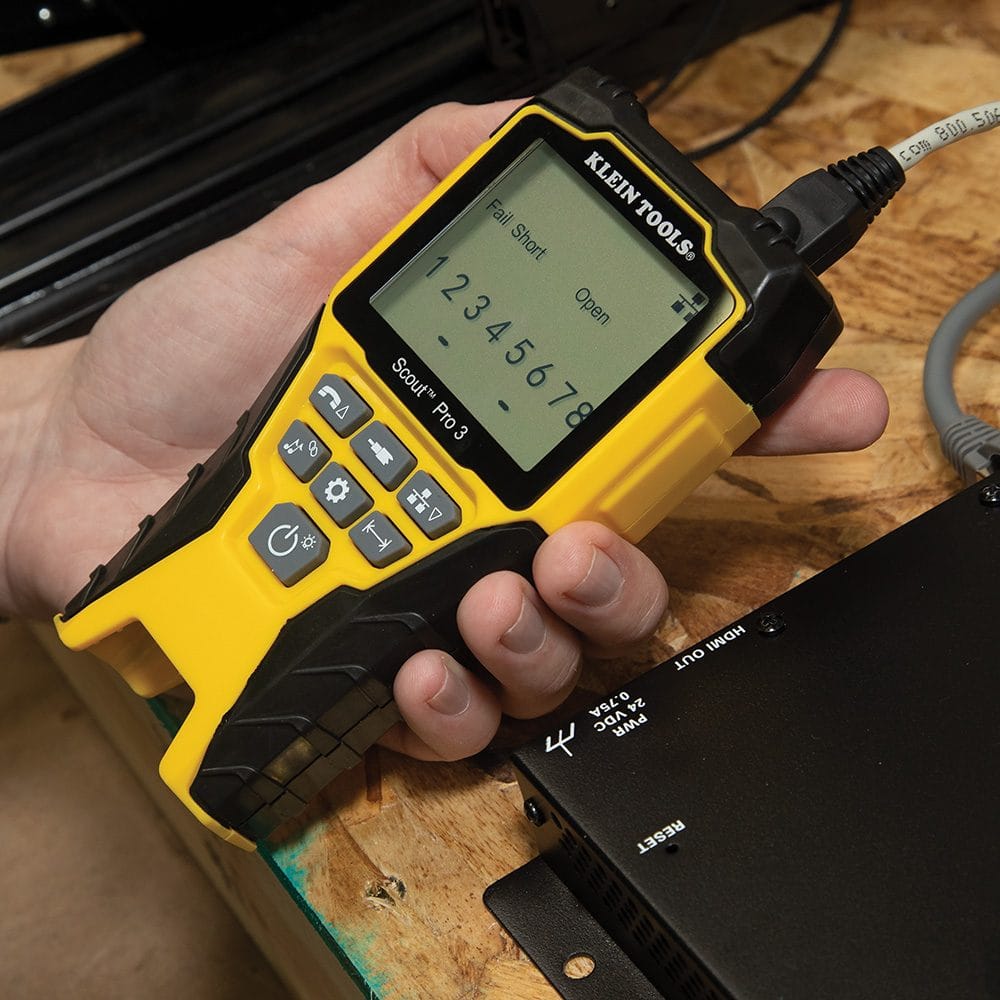Close-up view of the tester screen showing a Fail Short and Open fault notification while testing a white data cable.