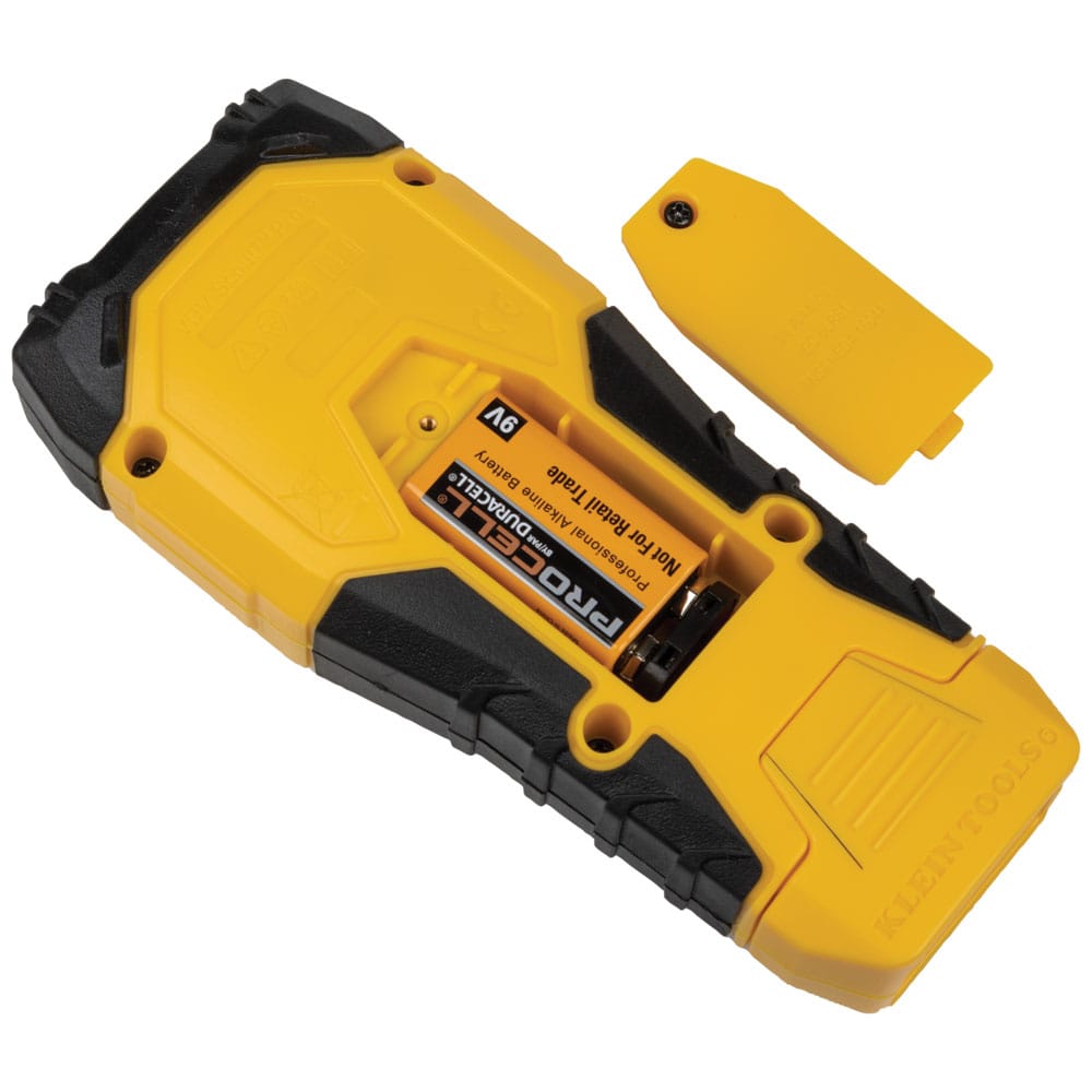 Rear view of the Klein Tools Scout Pro 3 with the battery compartment open, revealing the included 9V alkaline battery. The image also showcases the dockable self-storing remote #1 nestled into the base of the ruggedized housing.