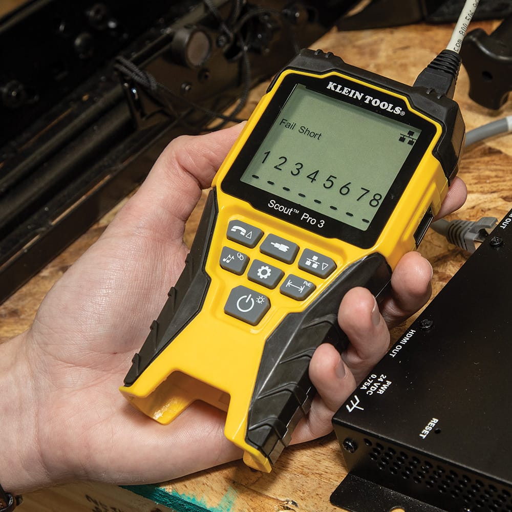 Action shot of the Scout Pro 3 being used to troubleshoot a network installation. The digital backlit LCD screen displays a Fail Short error message across specific wire pairs, illustrating the tester's precision in identifying wiring faults and split pairs.