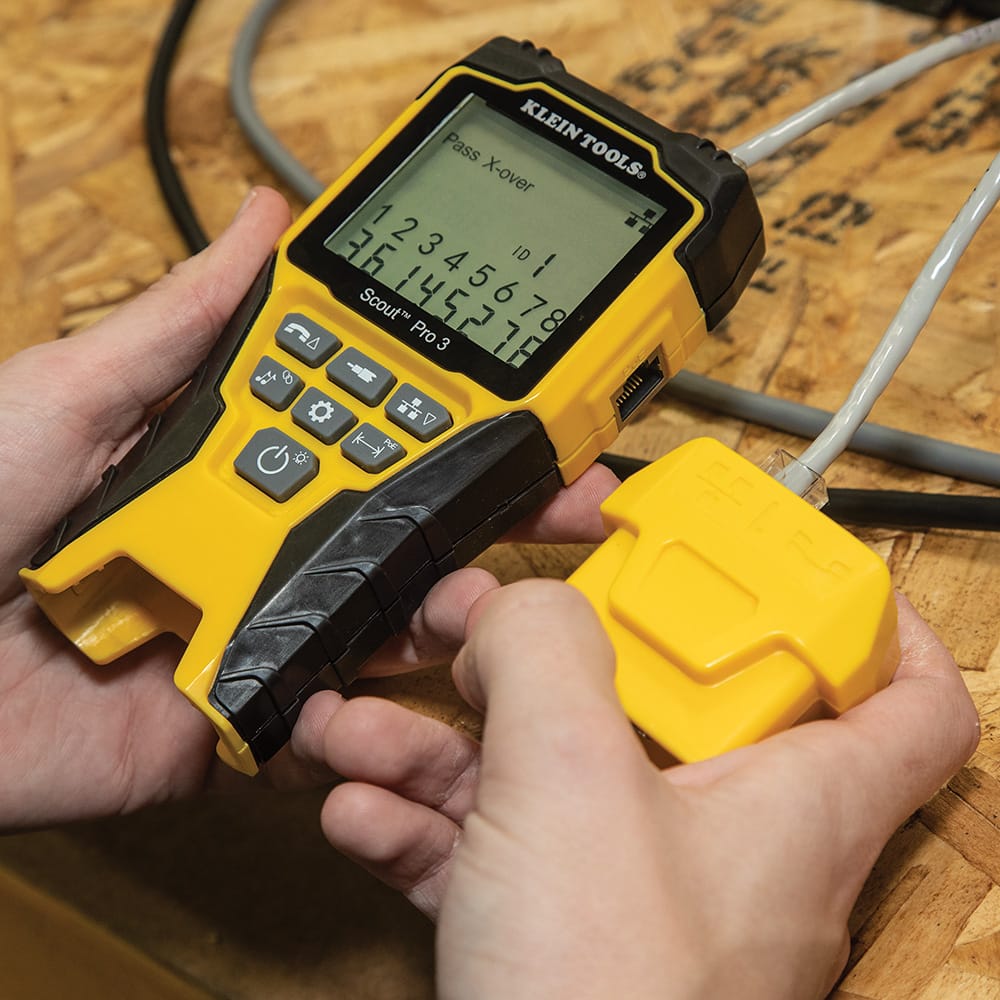 Action shot demonstrating the multi-port mapping feature of the VDV501853. A technician is shown connecting a Test + Map remote to an Ethernet cable while the main unit successfully identifies the remote ID and confirms a passed crossover wiremap.