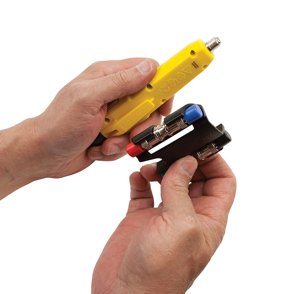 A lifestyle view of the Klein Tools VDV512101 kit. The image emphasizes the compact, pocket-sized dimensions of the tool, making it an essential diagnostic device for field technicians specializing in CATV, satellite, and security camera installations.