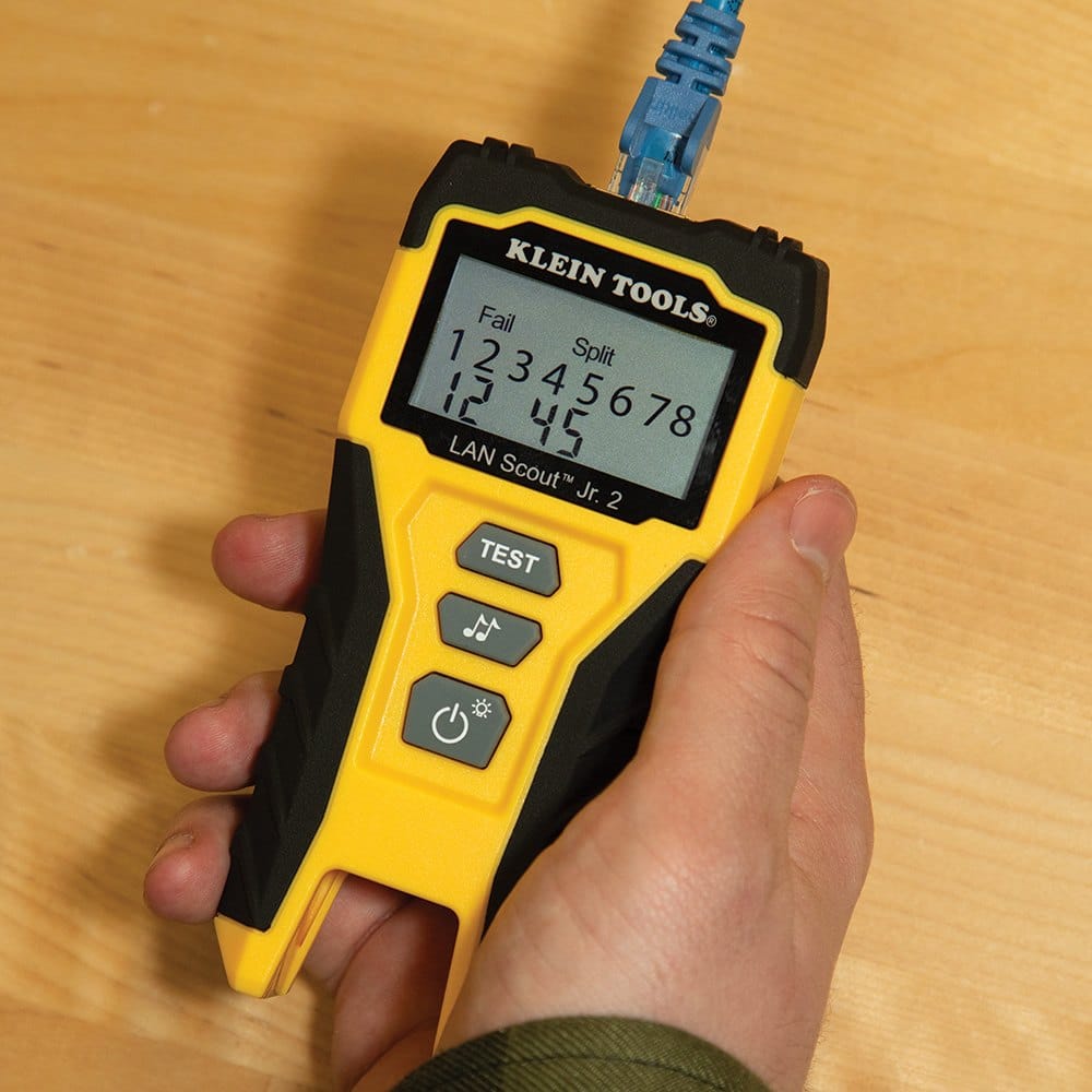 Handheld view of the Klein Tools LAN Scout Jr. 2 tester identifying a Fail Split fault on an Ethernet cable, with the backlit LCD showing specific wire pairs 1, 2, 4, and 5.