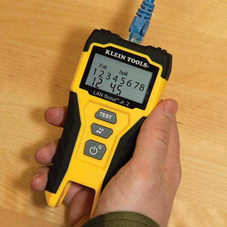 Handheld view of the Klein Tools LAN Scout Jr. 2 tester identifying a Fail Split fault on an Ethernet cable, with the backlit LCD showing specific wire pairs 1, 2, 4, and 5.