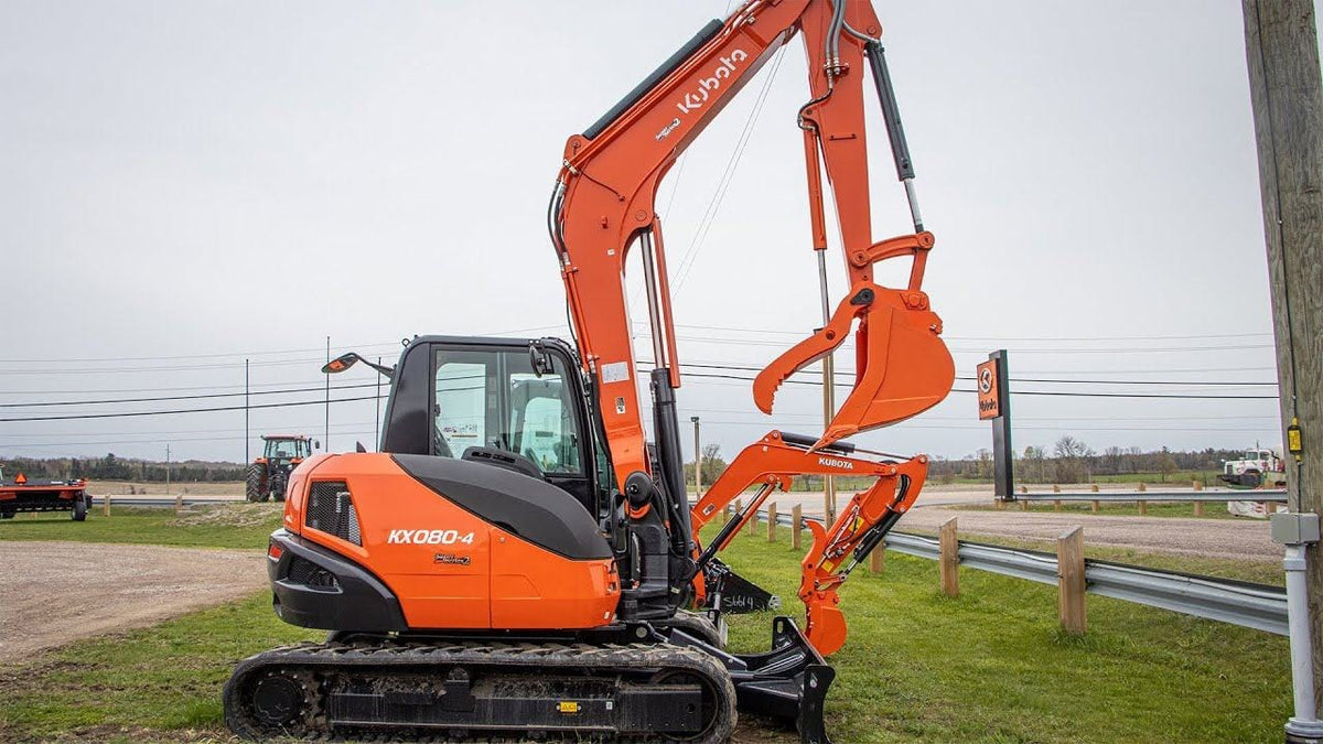 Kubota KX080-4 Power Utility Excavator resting on a large mound of dirt.