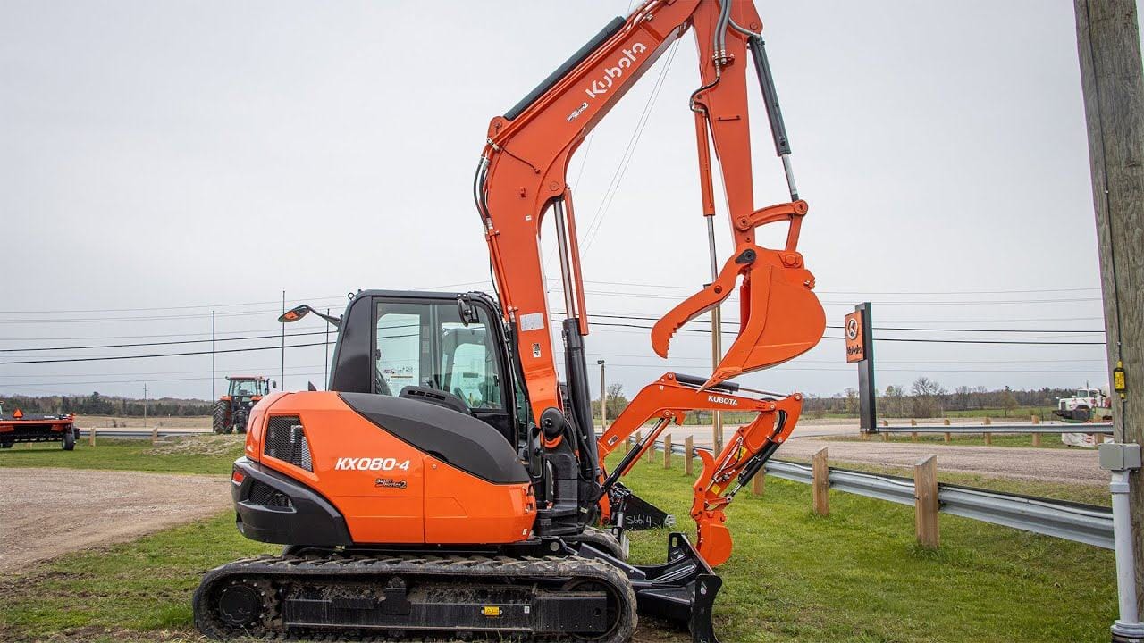 Kubota KX080-4 Power Utility Excavator resting on a large mound of dirt.