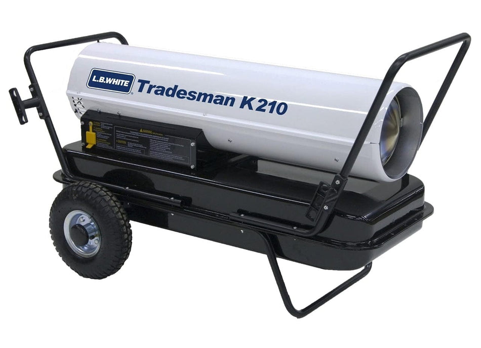 Angled front view of L.B. White Tradesman K210 portable heater featuring open nozzle, control panel with safety labels, and metal frame. Branding and model name are printed on the side.
