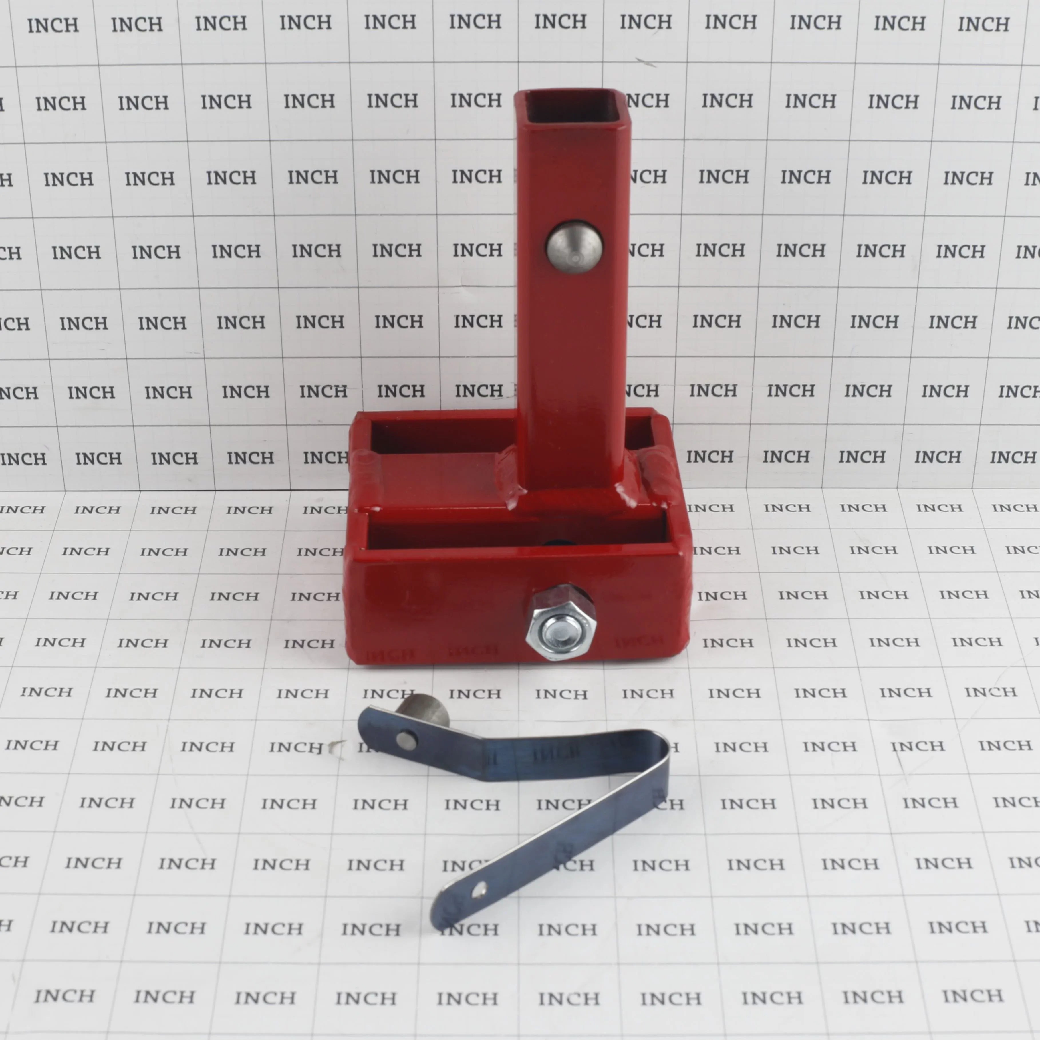 The Little Beaver anchor adapter displayed against an inch-grid background for scale, highlighting the heavy-duty welded steel construction of the foundation anchoring tool and its secondary securement pin.