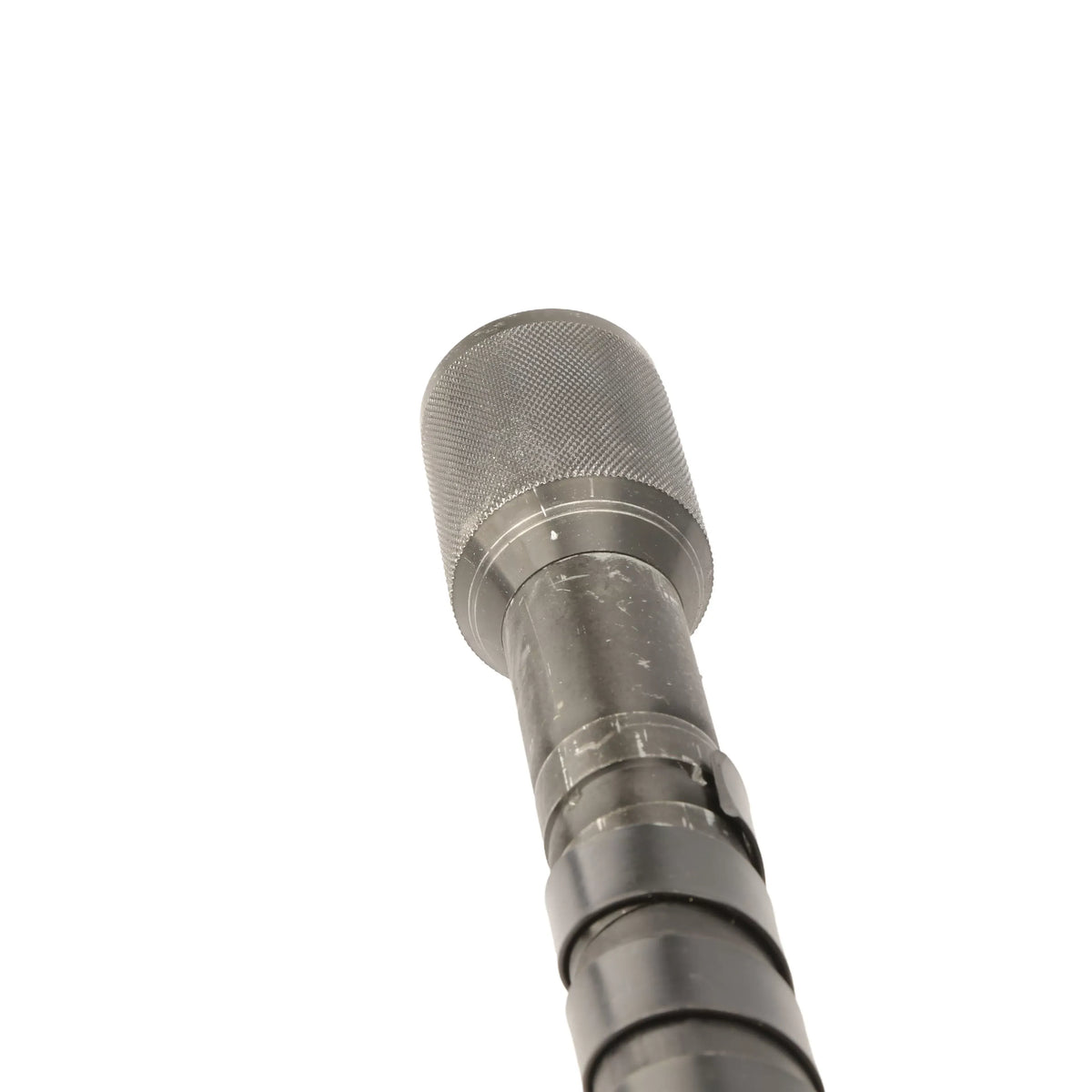 Straight-on close-up view looking down the length of the metal drive terminal connector end, highlighting the textured knurling pattern on the coupler collar designed for secure mechanical hand-grip connection to earth drill gearboxes.