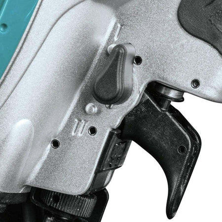 A close-up studio shot of the 2-mode selector switch located just above the trigger on the Makita AN454 nailer.