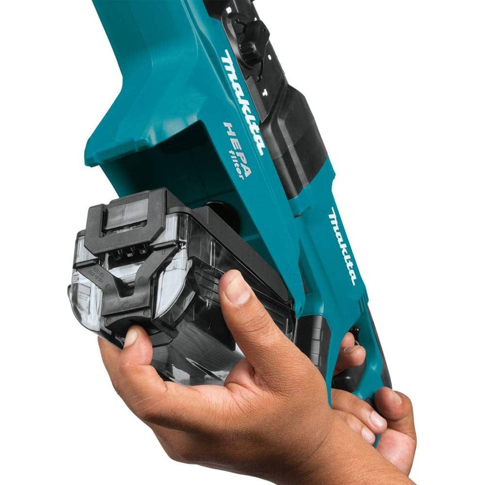 Close-up of hands removing transparent dust container from Makita HEPA dust extractor. Tool is teal with visible branding and filter label