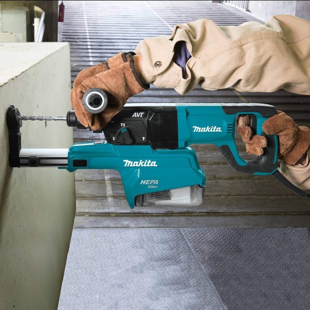 Person using Makita HR2661 rotary hammer drill with HEPA dust extractor to drill into concrete. Tool features AVT vibration control and is operated in a commercial stairwell setting.