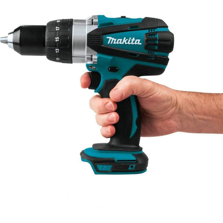 Hand holding a Makita cordless drill on a white background