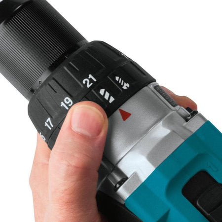Hand holding a cordless drill with speed control dial on a white background