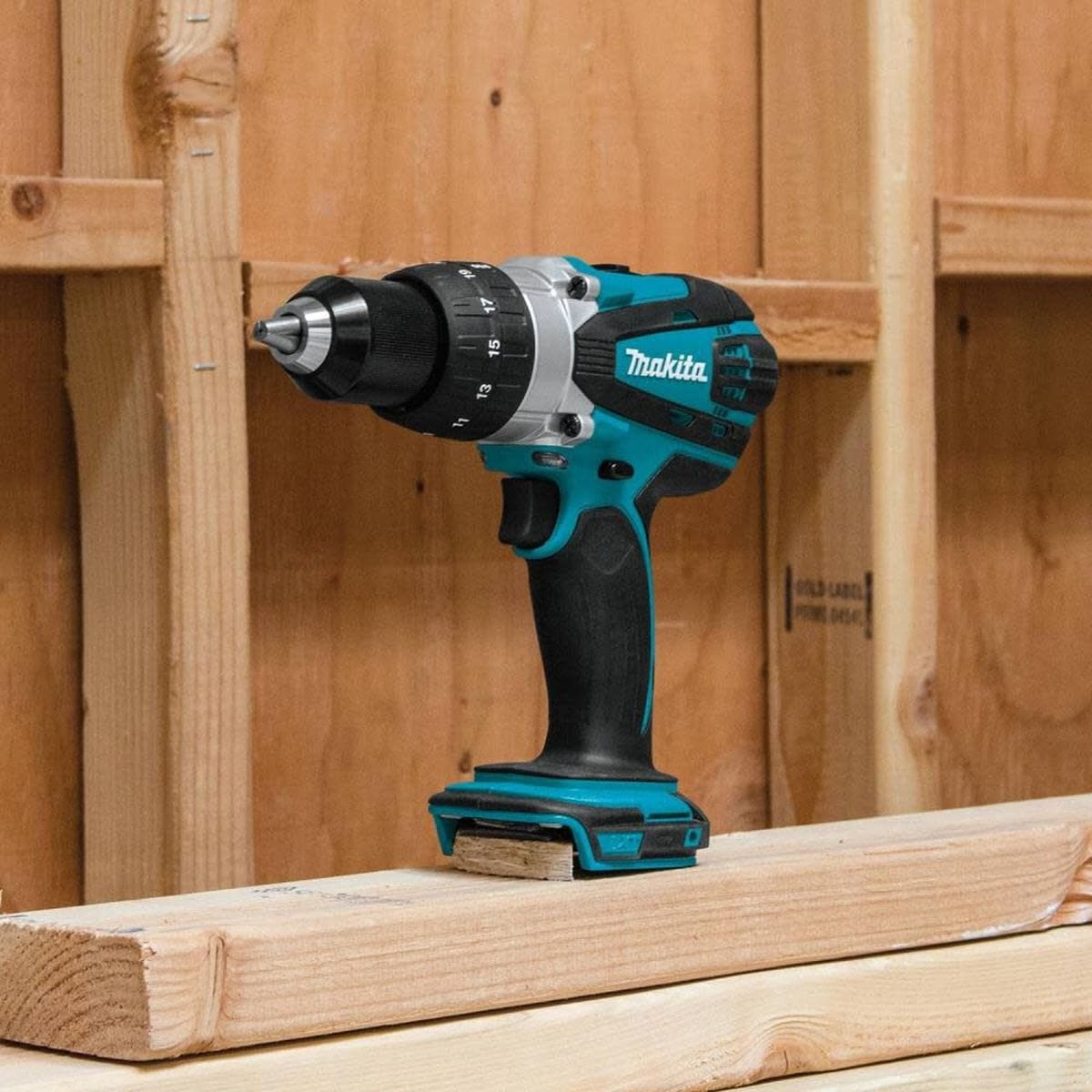 Makita cordless drill on a wooden surface with a wooden panel background