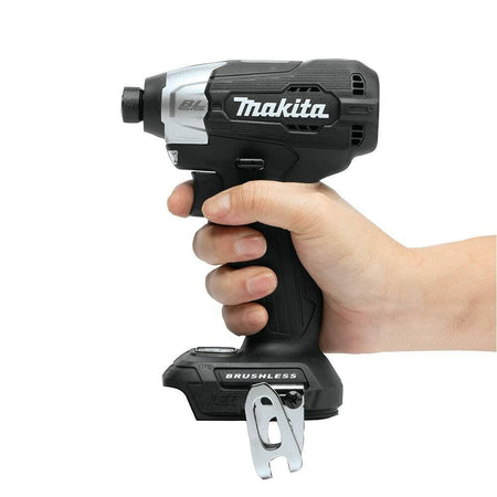 A hand holding the compact Makita XDT18ZB impact driver to demonstrate its small, ergonomic size.