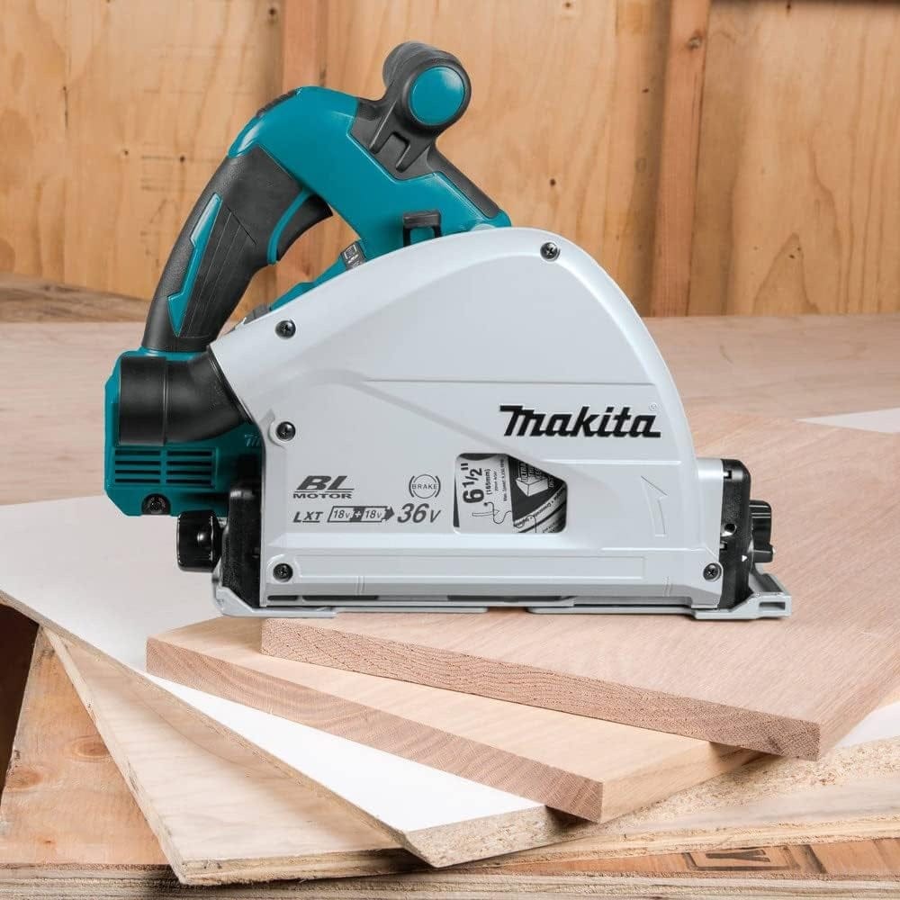 Makita XPS01Z cordless plunge circular saw placed on stacked wooden boards in a workshop setting. Tool features teal and white housing, ergonomic black handle, blade guard, and visible labels for "BL MOTOR," "LXT 18V x2 = 36V," and "6-1/2" blade size. Highlights jobsite readiness and precision cutting capability.