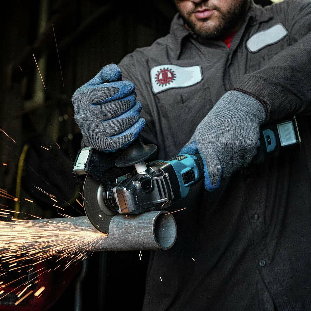 Person using angle grinder to cut metal pipe; sparks flying from contact point, user wearing gloves and work uniform, emphasizing industrial metalworking.