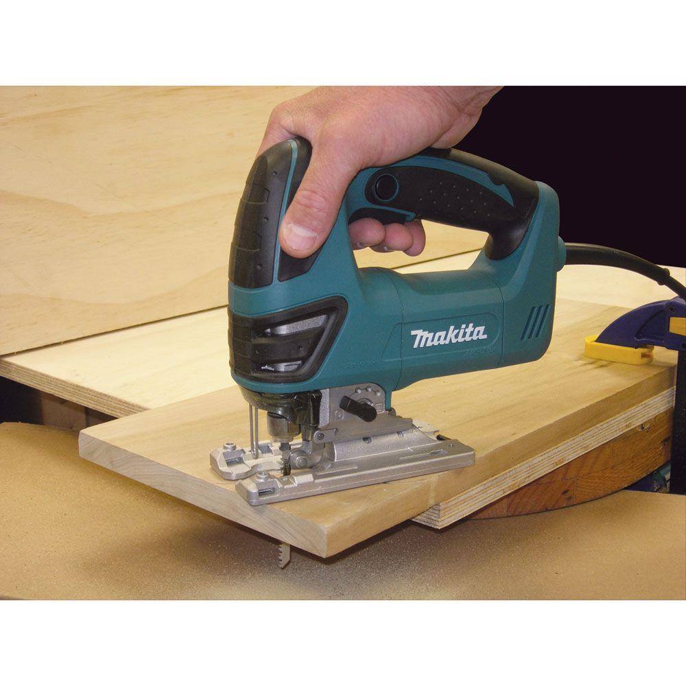 The Makita 4350FCT top handle jig saw stored inside its heavy-duty teal hard carrying case alongside organized accessories for easy transport to the jobsite.