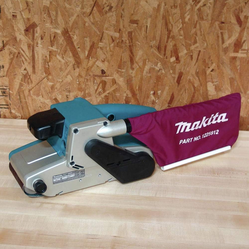 Belt sander with a purple Makita dust bag on a wooden surface.