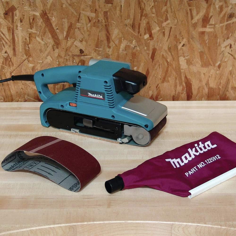 Makita belt sander with sandpaper and a cloth on a wooden surface