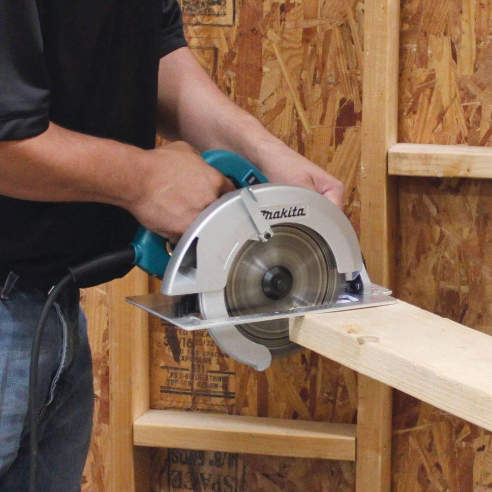 A professional builder using the Makita 5007FA 7-1/4 inch circular saw to crosscut a wooden beam, demonstrating the tool's power and balance.