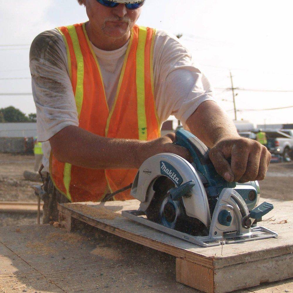 A professional builder in safety gear using the Makita 5007MG magnesium saw on a construction site, demonstrating the tool's balance and power during heavy-duty roofing tasks.
