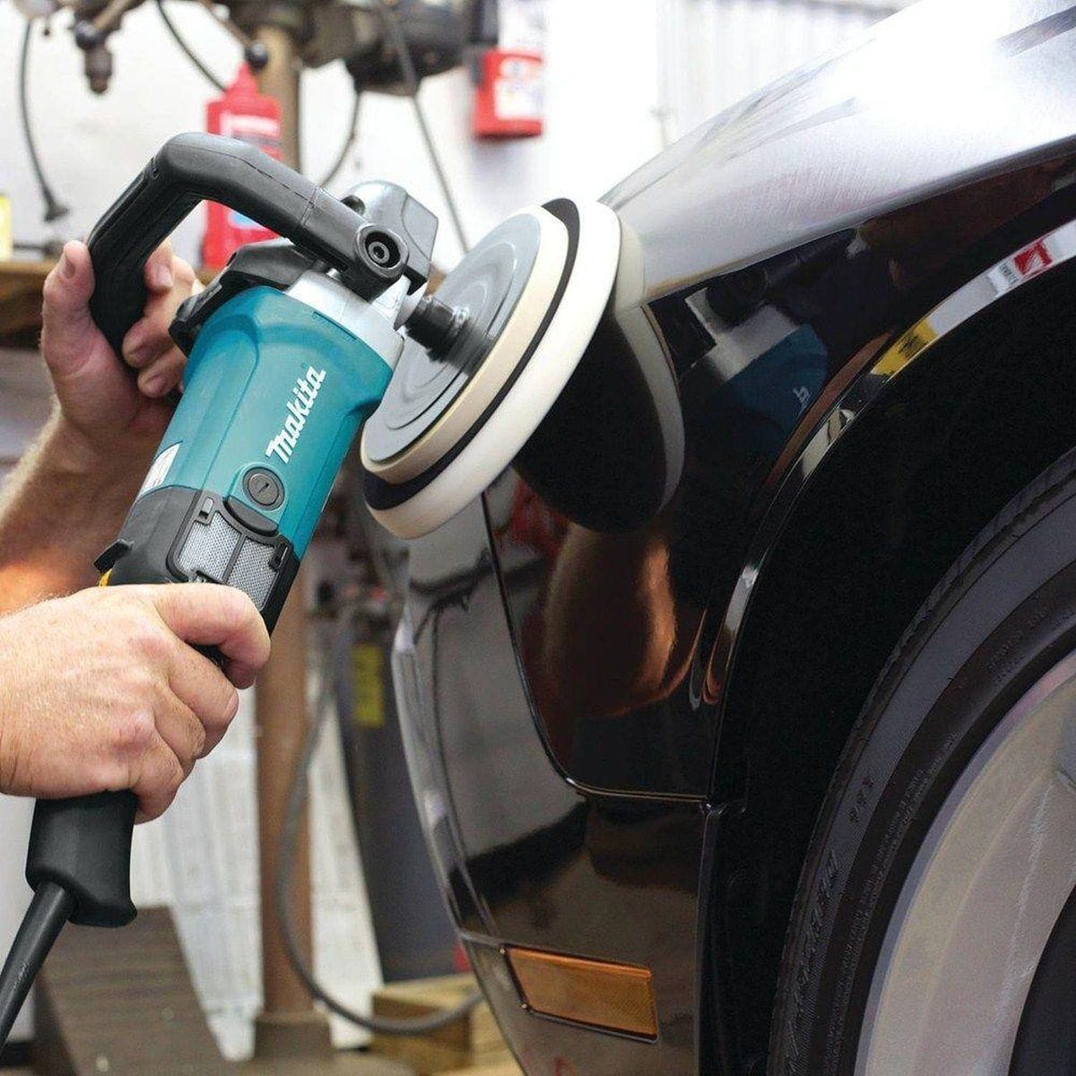 Detailed view of the integrated wire mesh intake cover on the Makita 9237C, designed to prevent wool fibers and abrasive debris from entering and damaging the motor.