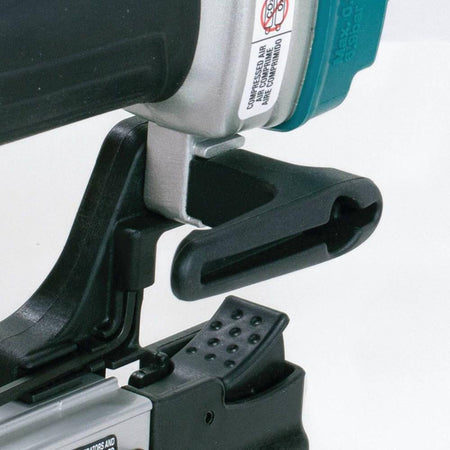 Detailed view of the reversible belt hook on the Makita AF353 23 gauge air powered pin nailer, allowing the tool to remain conveniently close by during cabinet construction.