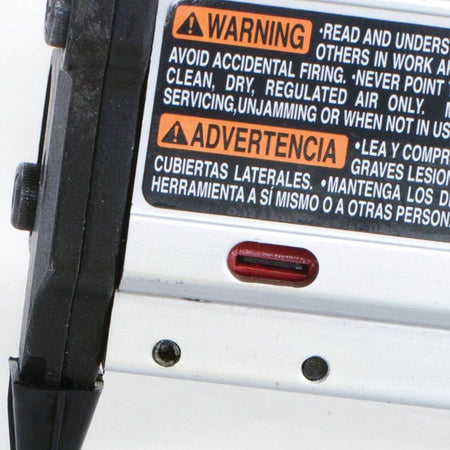 Close-up of the red nail lock-out window indicator on the Makita AF353 pin nailer magazine, alerting the woodworker when to reload 23 gauge pins to prevent dry-fires.